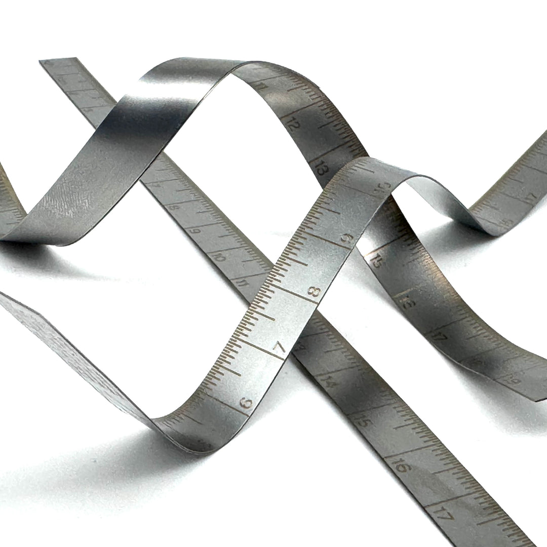 Metallic tape measure coiled on a white background