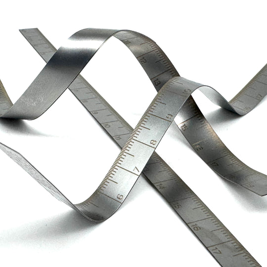 Metallic tape measure coiled on a white background